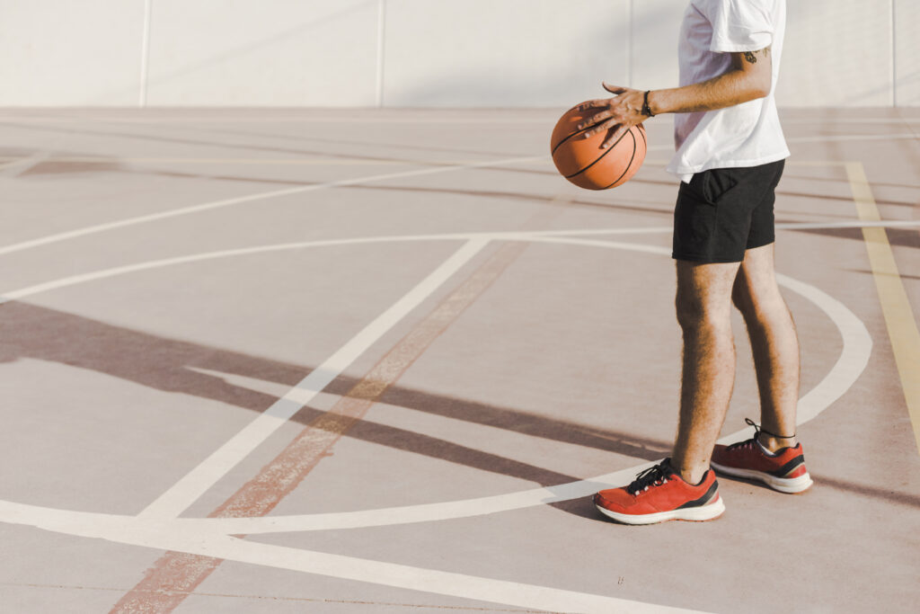 man standing on court holding basketball